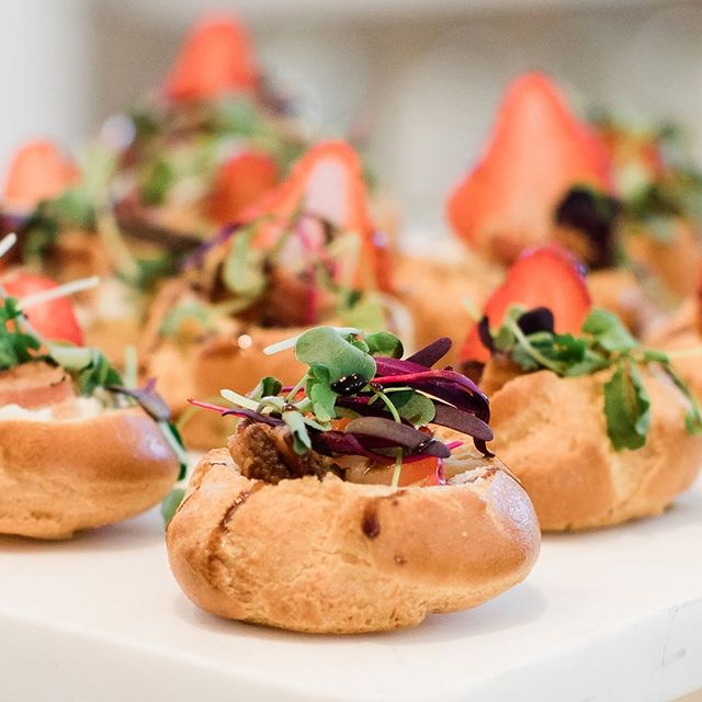 Round bread topped with salad leaves and a strawberry slice | PartySlate