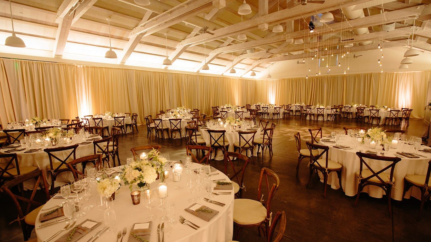 Dinner reception with amber uplighting and drapery at Solage, an Auberge Resort | PartySlate
