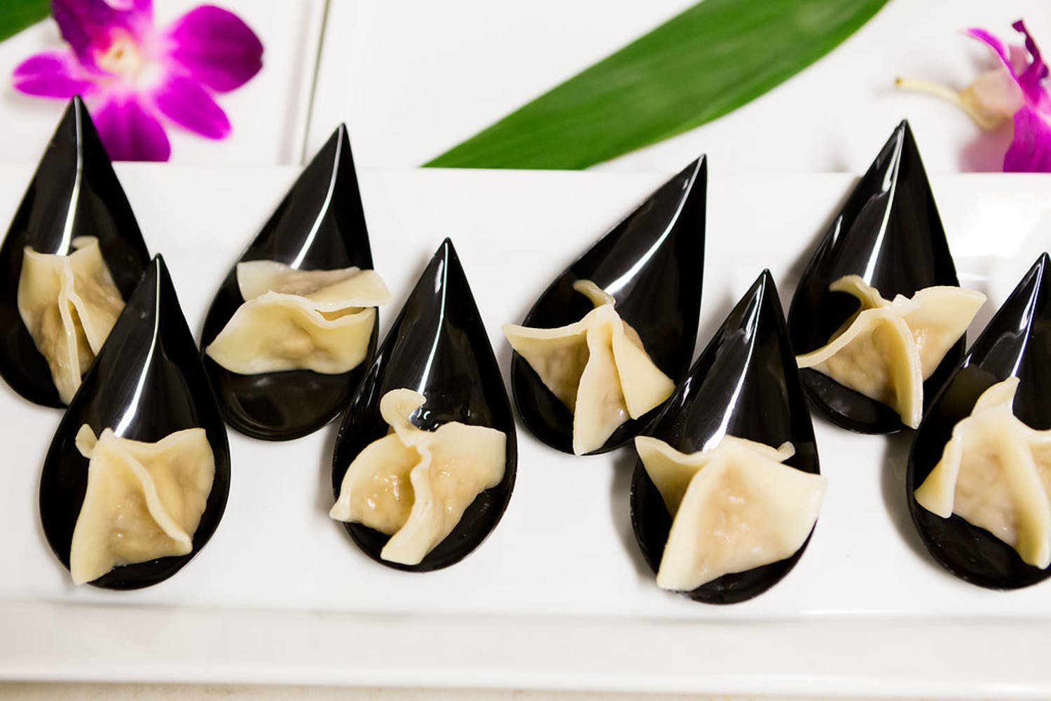dumpling bites on black tear drop spoons