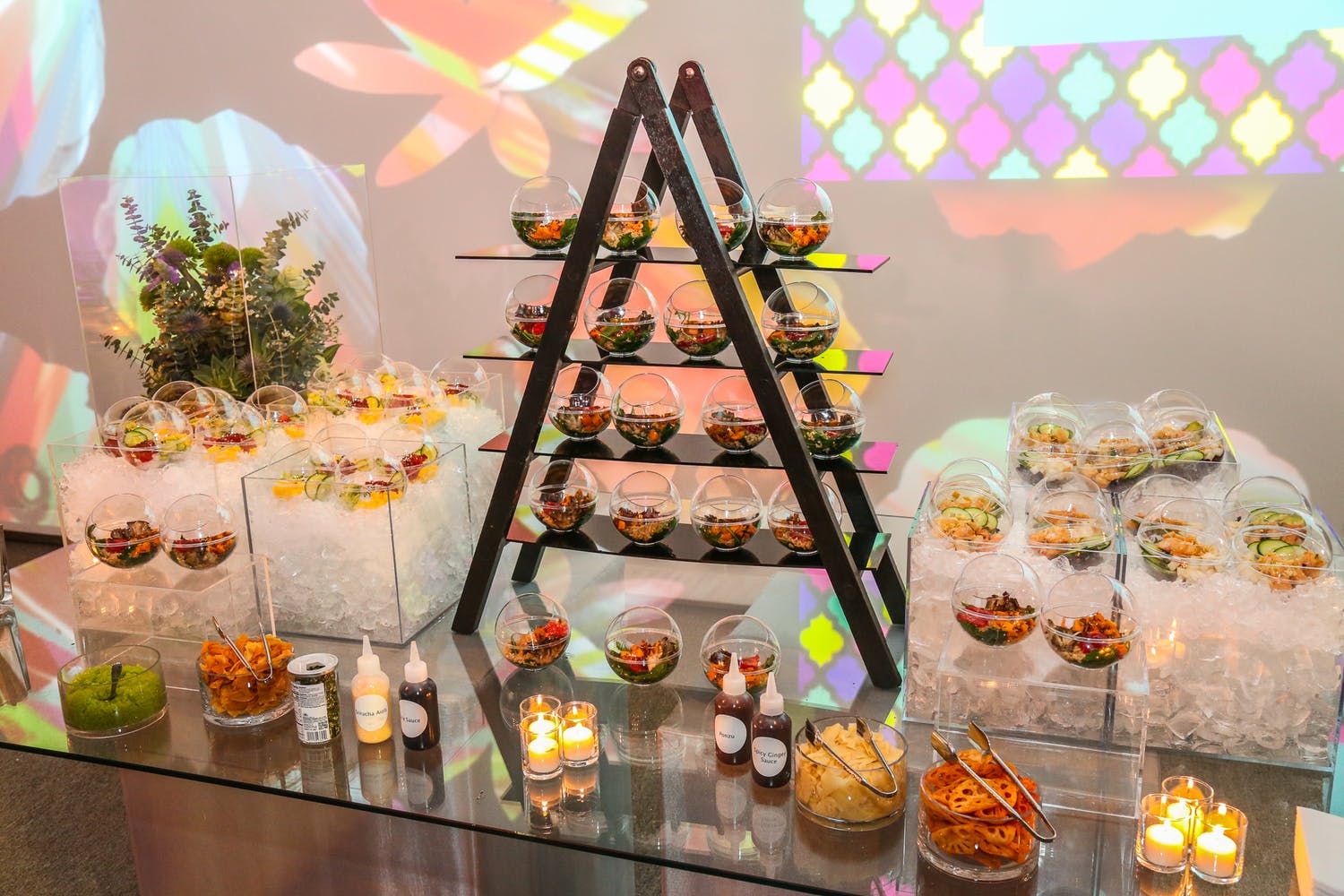 candlelit catering station with pyramid display and globed dishware
