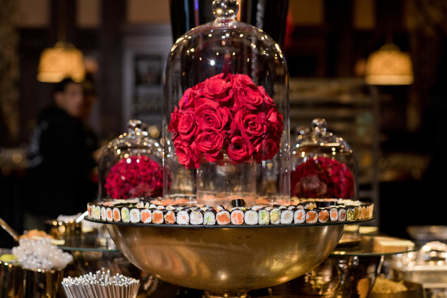 sushi display with cloche bell glass and red roses