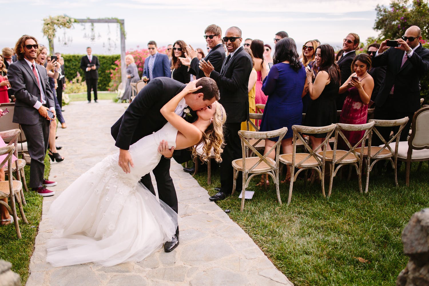 bride and groom kissing as they leave wedding ceremony