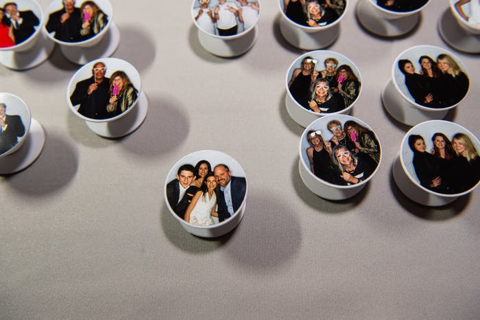 pop sockets with photo booth photos on them decorate a table.