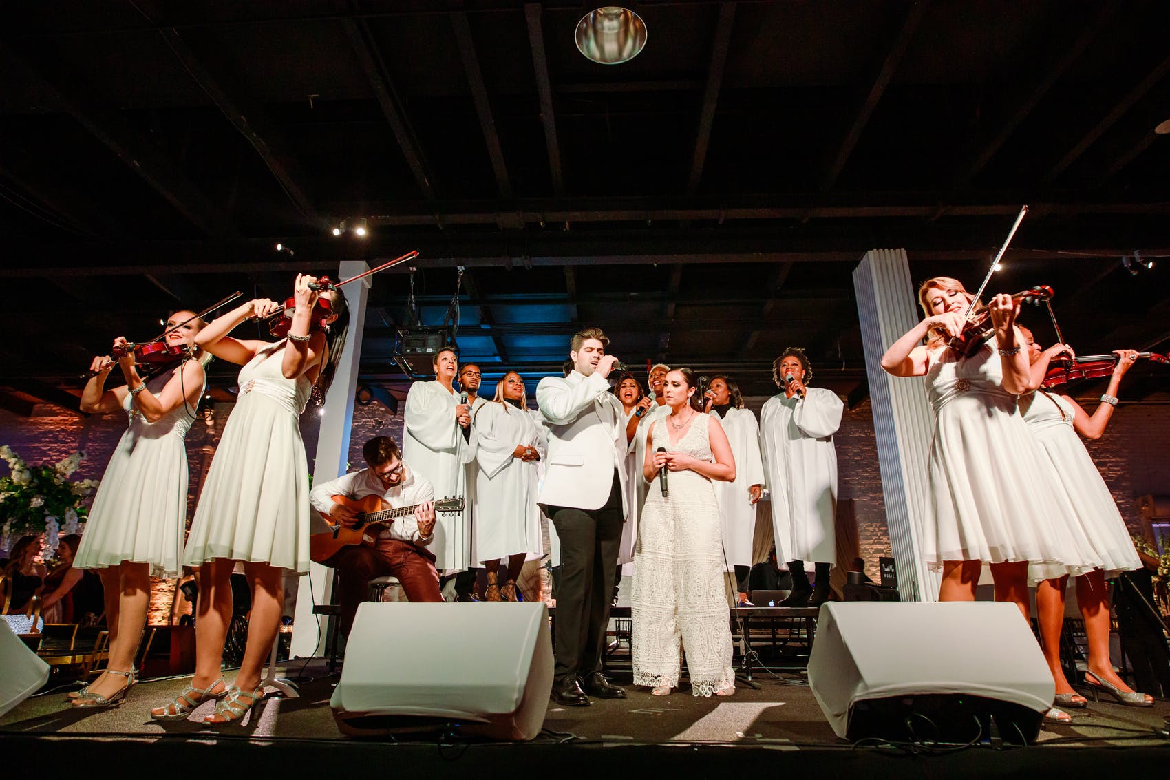 band and orchestra performing dressed in all white