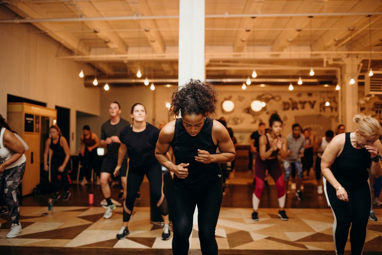 a work out instructor leads a class of people working out.
