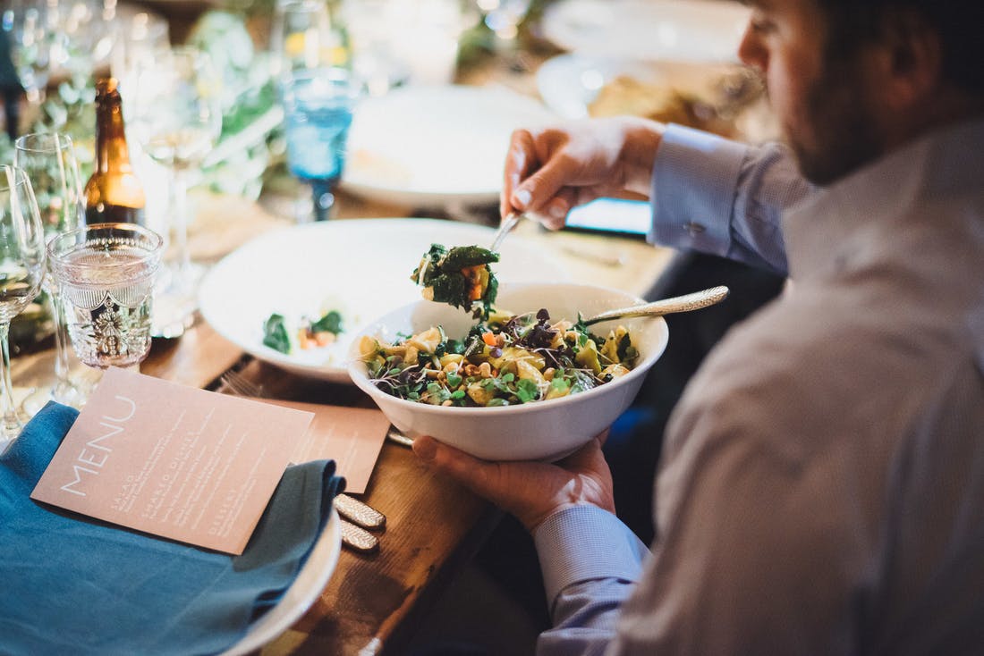 Man serving himself all-vegan salad with chickpeas.