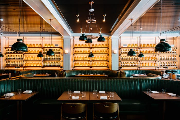 restaurant with lit bar and wall full of bottles