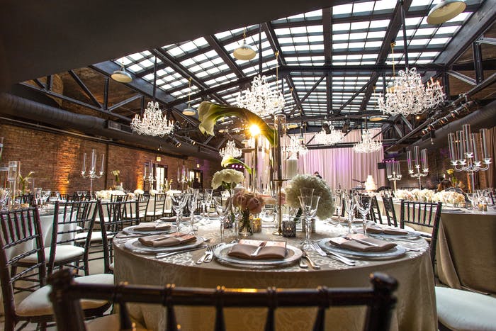 Paned glass ceiling with brick walls and chandeliers.