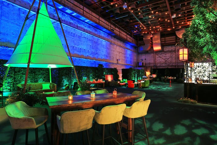 A rectangular table with a green triangular centerpiece and a blue screen in the background