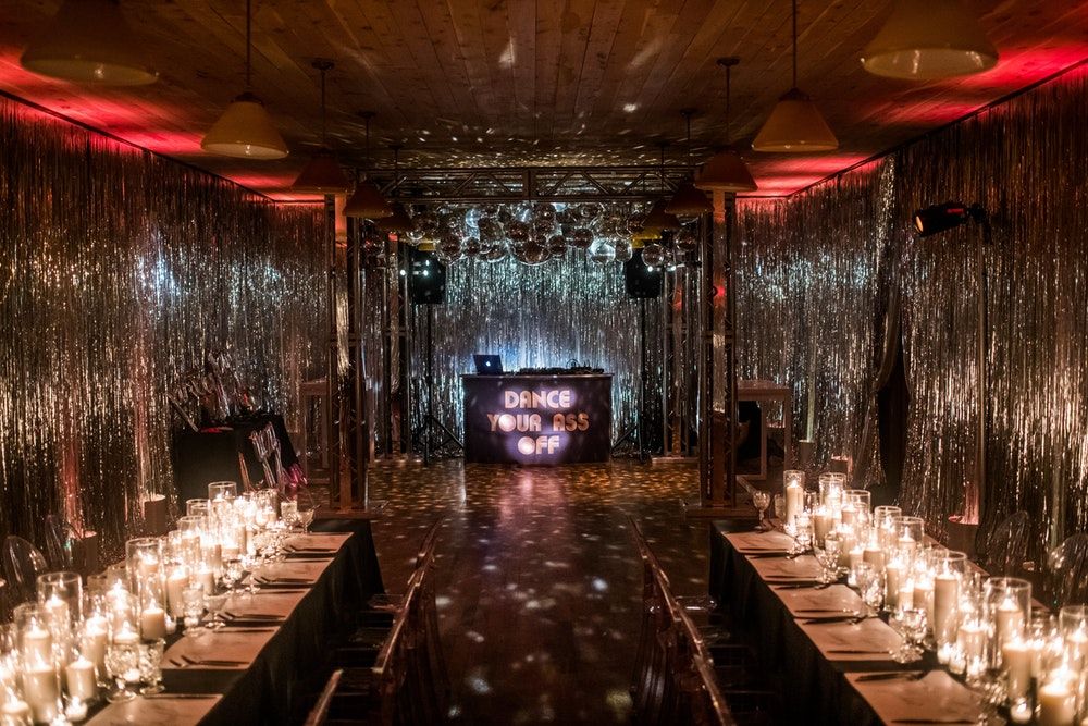 Disco 50th Birthday Party Theme with Red Lighting and Silver Tassel Walls | PartySlate