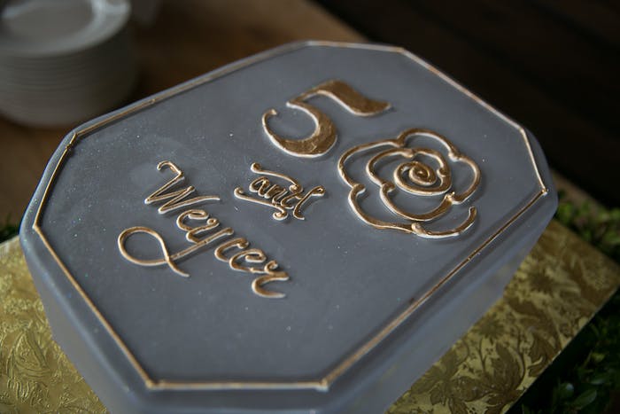 Stone-Shaped Gray 50th Birthday Cake With Gold Icing Lettering | PartySlate