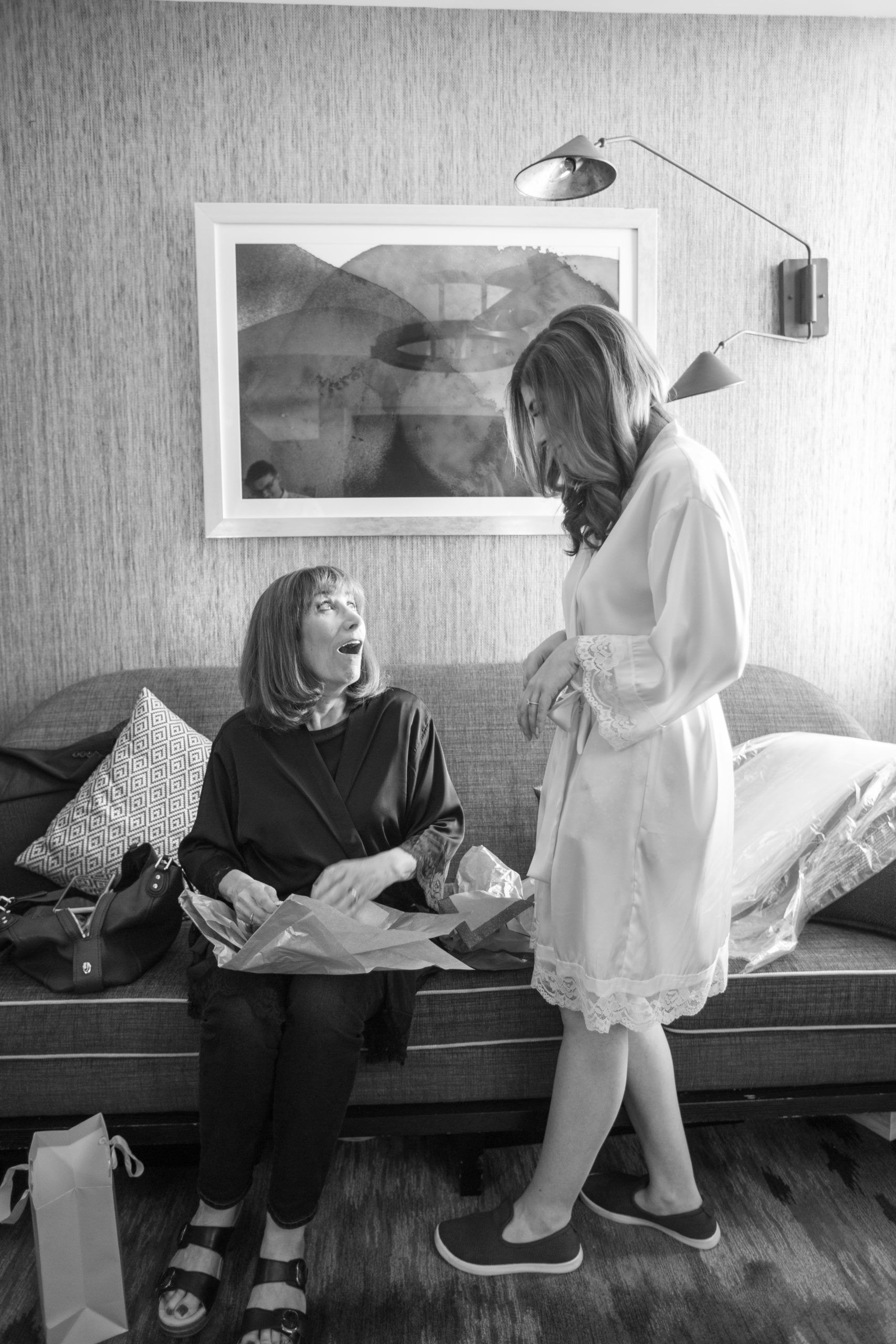 Mother oohs and ahhh at a gift given by her daughter the bride.