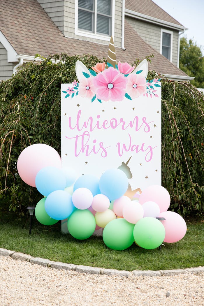 A large sign in front of bushes that reads 