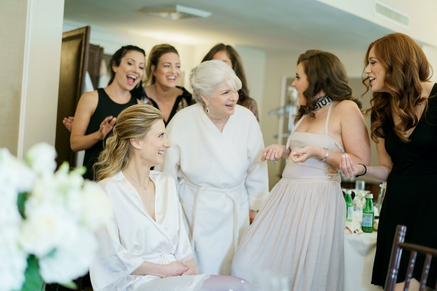 Mother of bride and friends get ready with bride before wedding.