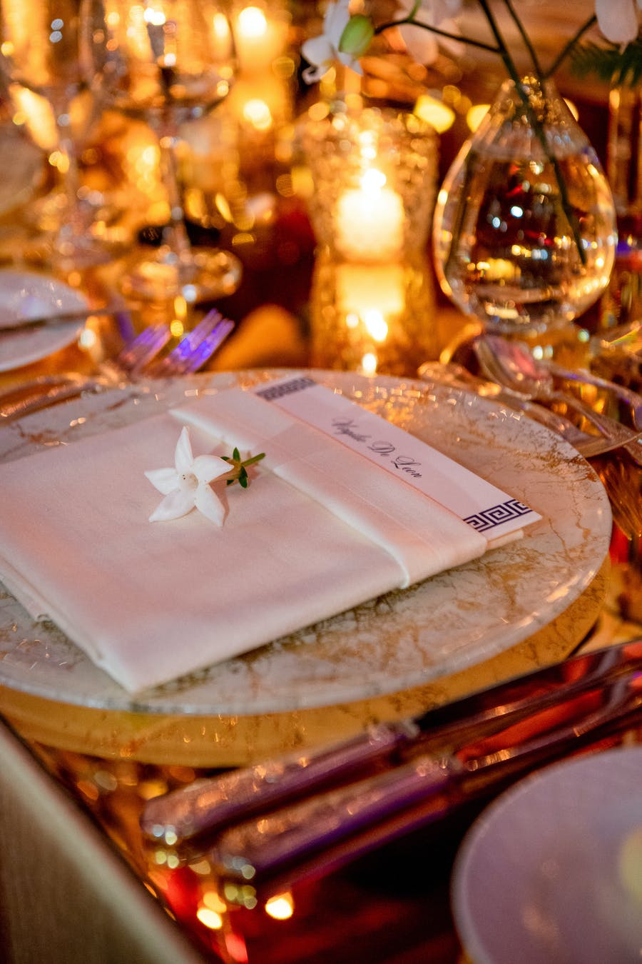 Table setting with gold décor and a white flower