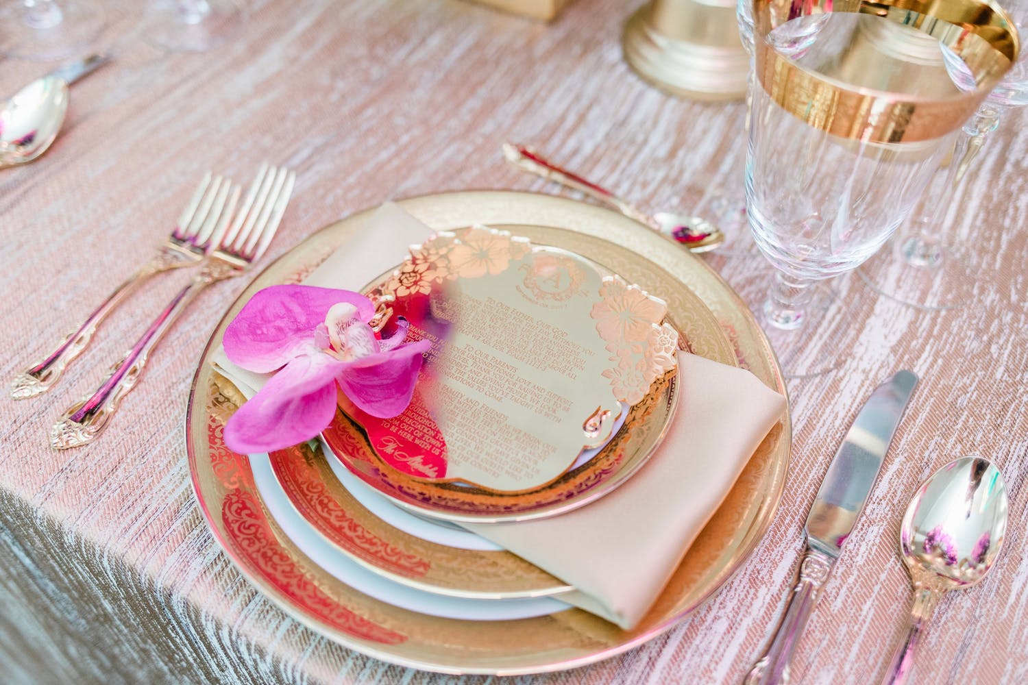 Dinner plate with pink orchid and artfully designed menu.