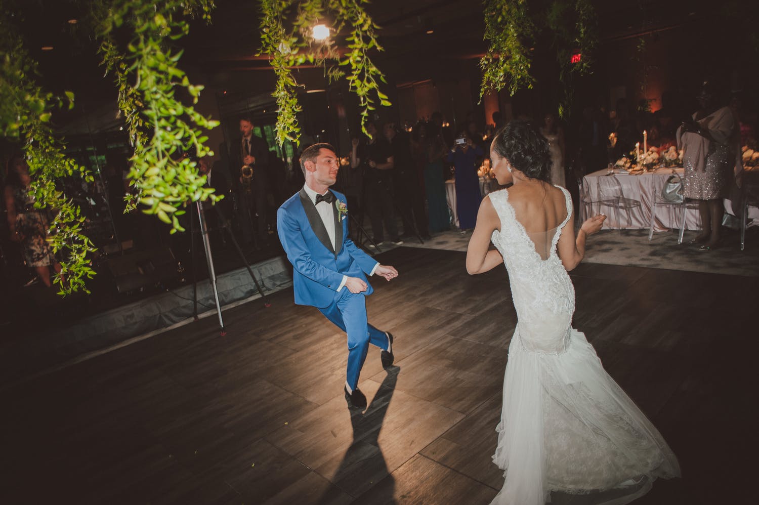 Bride and groom dancing with greenery draping down | PartySlate