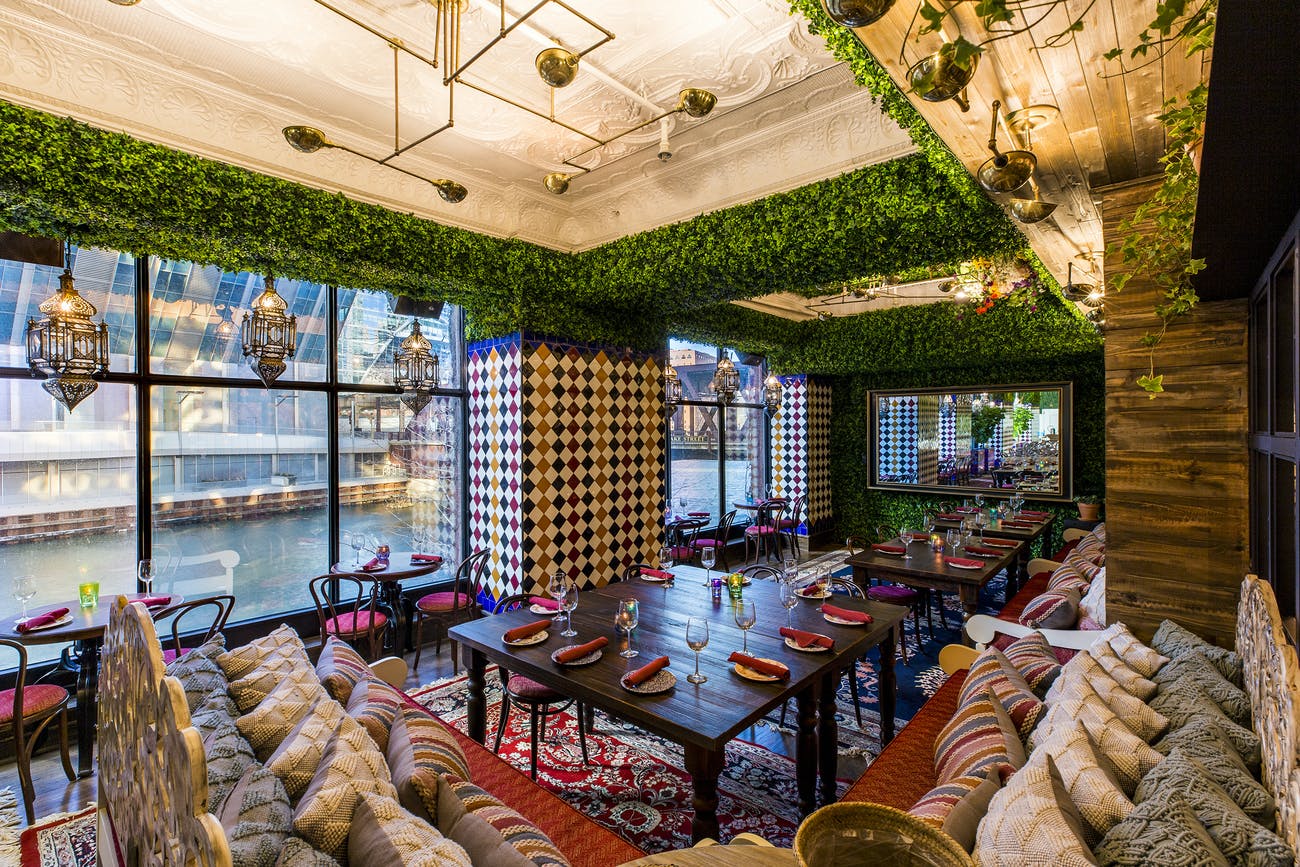 Large dinner tables with patterns on the walls and a view of the Chicago river, an event space for your sweet sixteen | PartySlate
