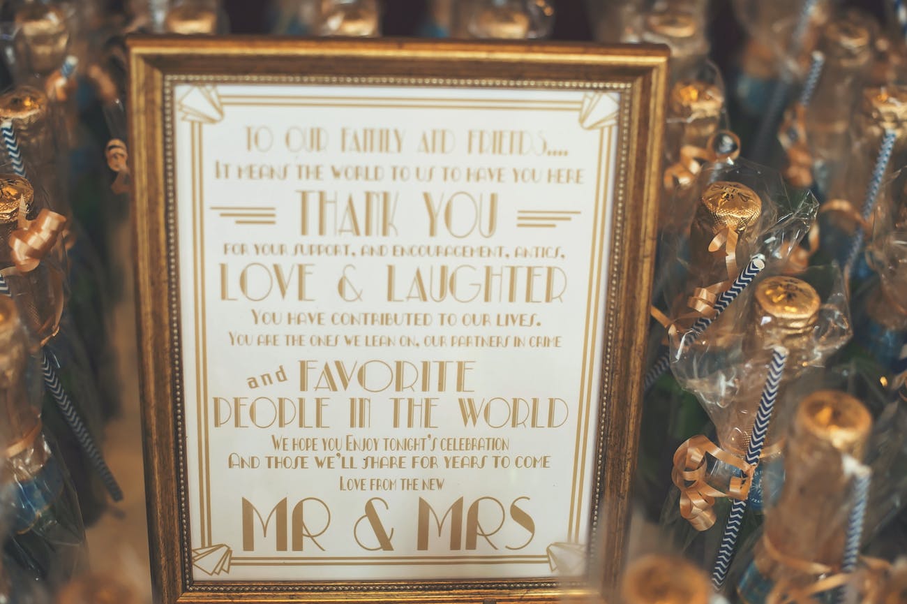 Deco Gatsby theme signage with mini champagne bottles | PartySlate