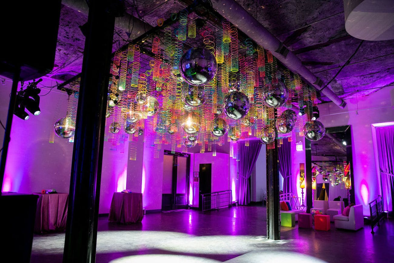 Neon slinkies suspended above a dance floor