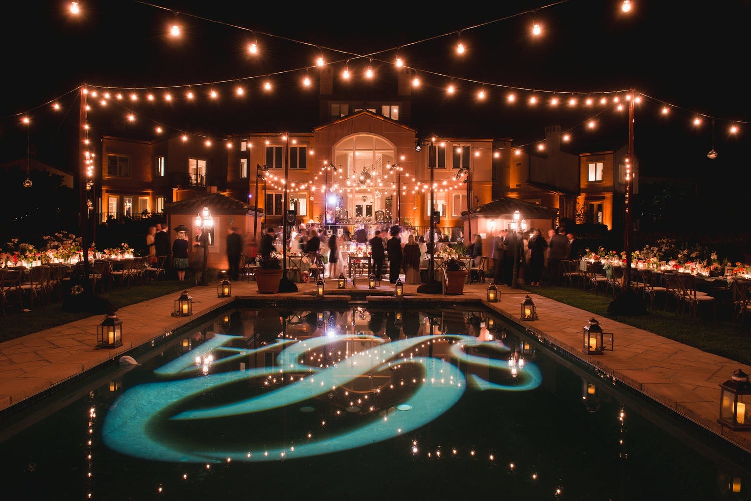 Nighttime Party at Private Residence With String Lighting and Monogram Pool Décor | PartySlate