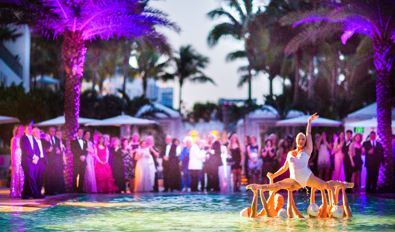 Water Ballerinas Perform in Pool at Wedding Party With Purple Uplit Palm Trees | PartySlate