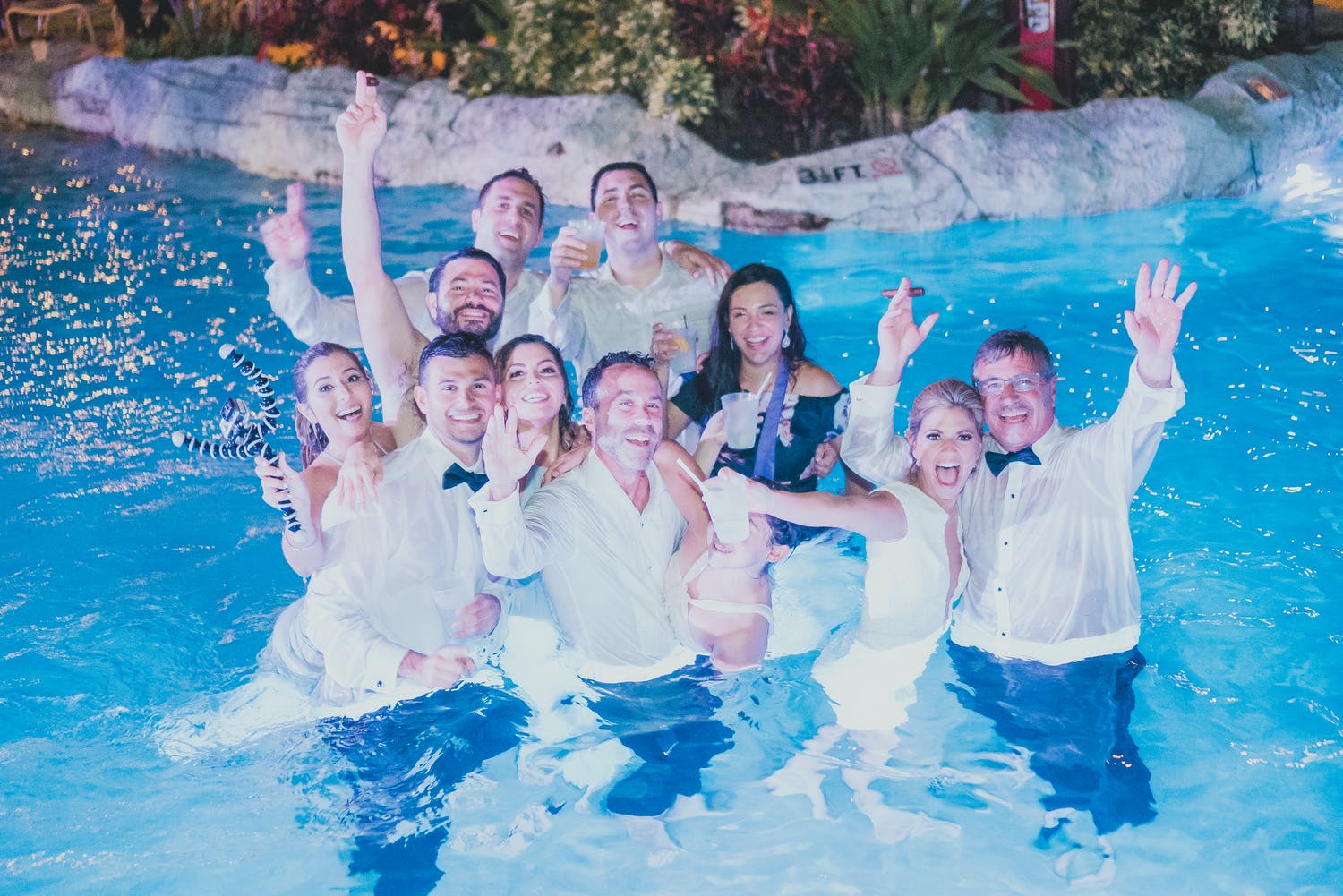 Wedding Party Poses After Jumping in Pool at End of Celebration | PartySlate