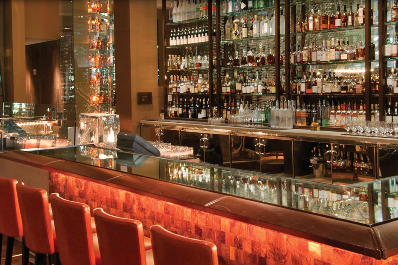 BOURBON STEAK Bar With Orange Seating and Glass Shelving | PartySlate