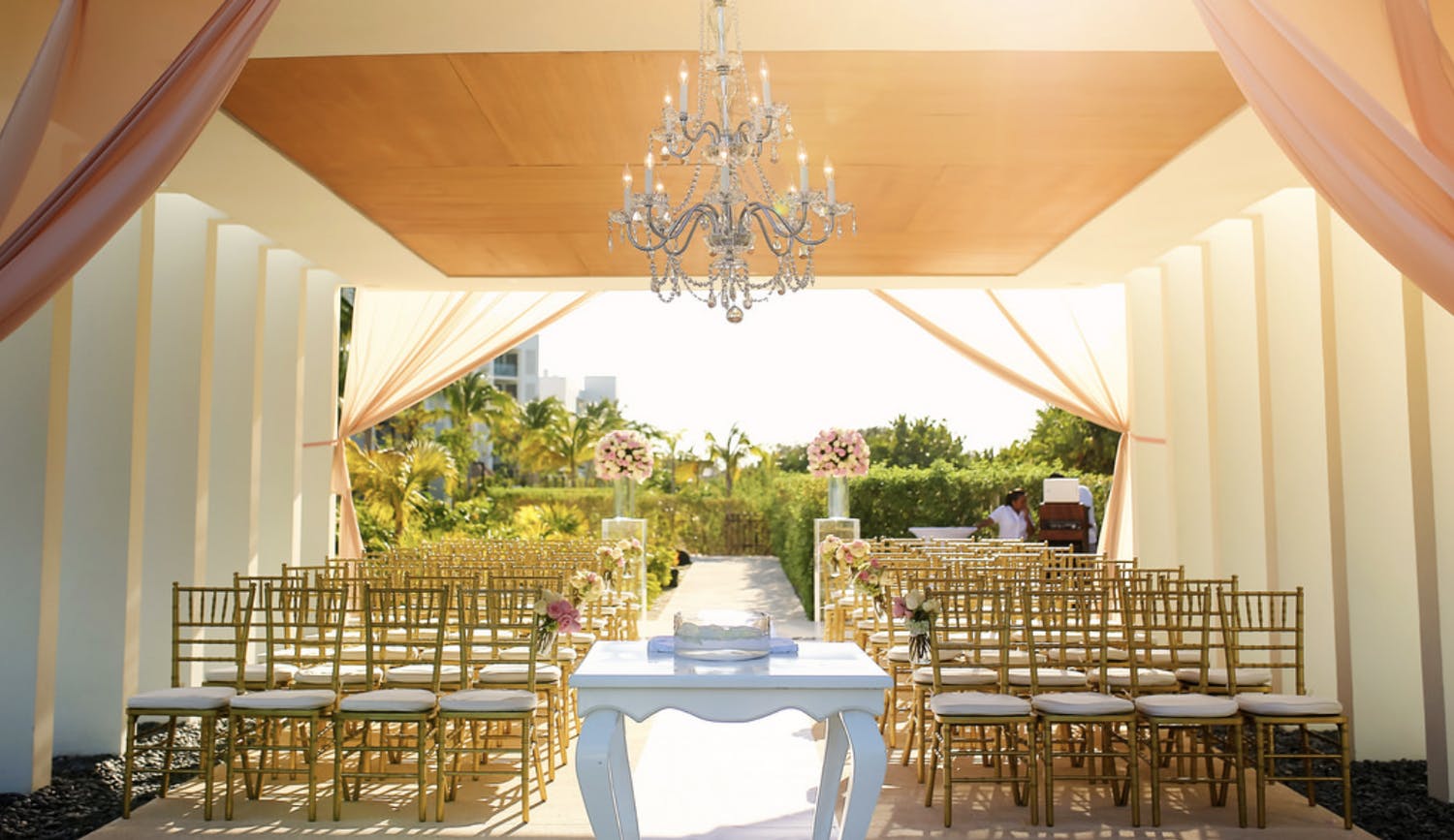 Covered Outdoor Wedding Ceremony With Pink and White Drapery and Chandelier | PartySlate
