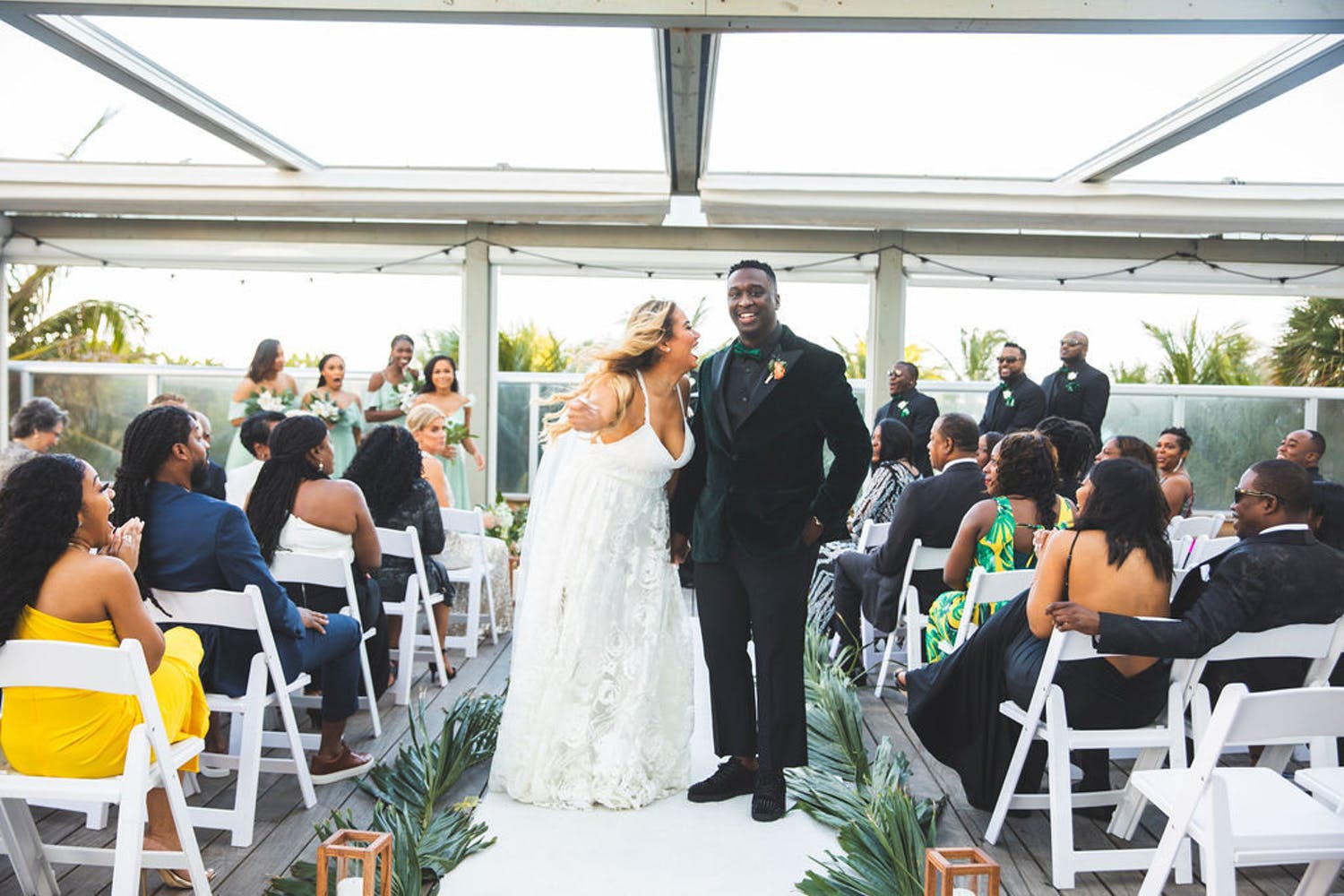 Bride and Groom Pose During Recessional Down Aisle | PartySlate