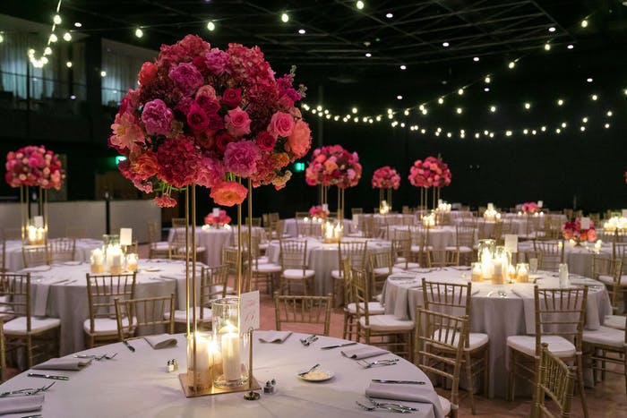 Grand Ballroom at The Statler Dallas with String Lights and Tall Centerpieces of Red Flowers | PartySlate