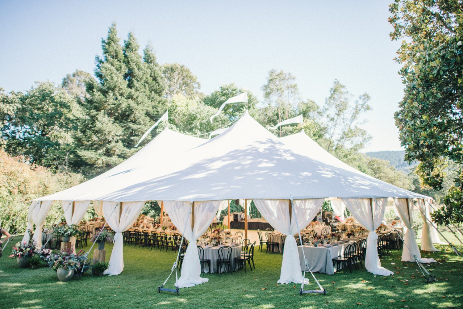 White canopied reception area on manicured lawn surrounded by greenery at Annadel Estate Winery in Santa Rosa, CA | PartySlate