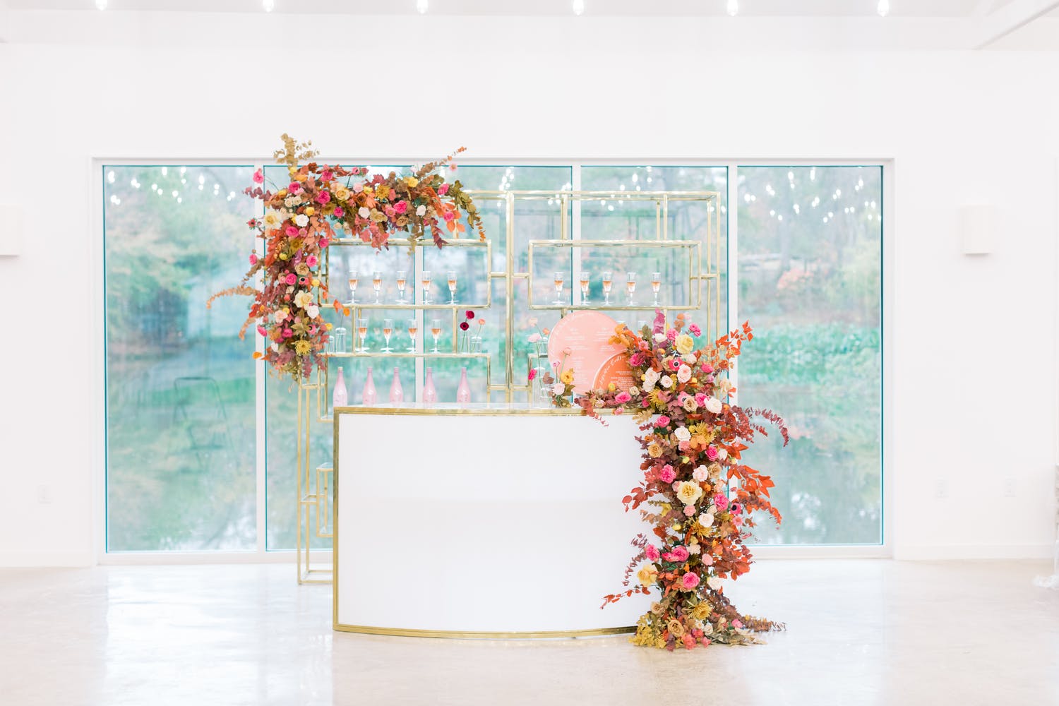 Mod and Glam White Party Bar Area with Cascading Warm-Hued Florals | PartySlate