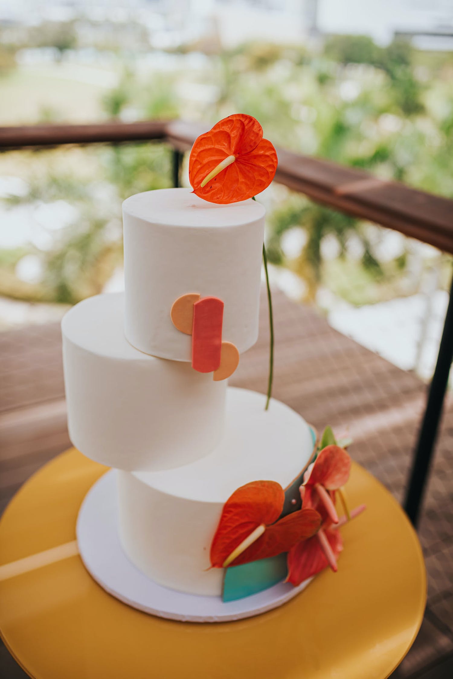 White three-tier circle wedding cake with unaligned layers and a tropical design | PartySlate