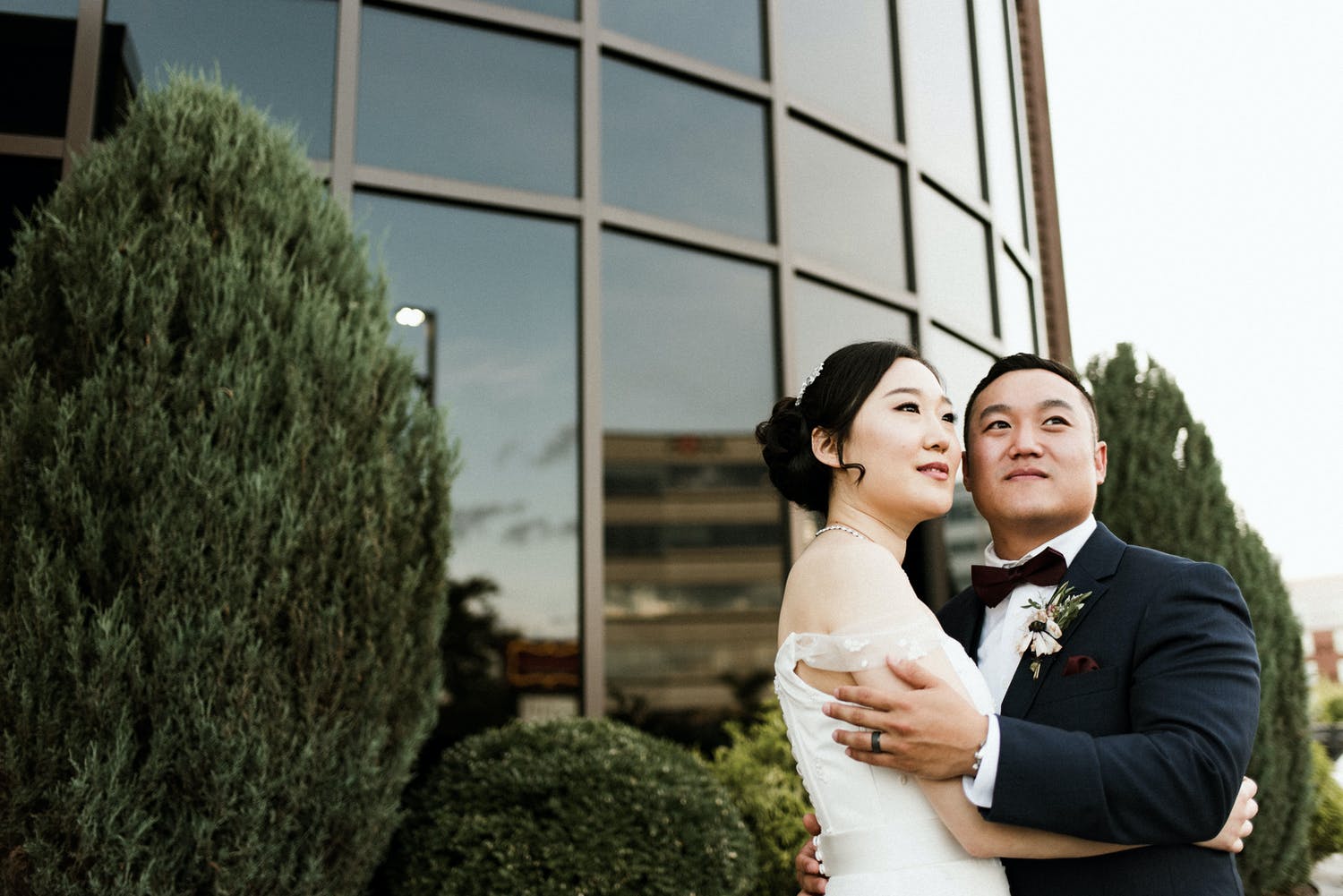 First Look fo Bride and Groom in Front of Glass Modern Building | PartySlate