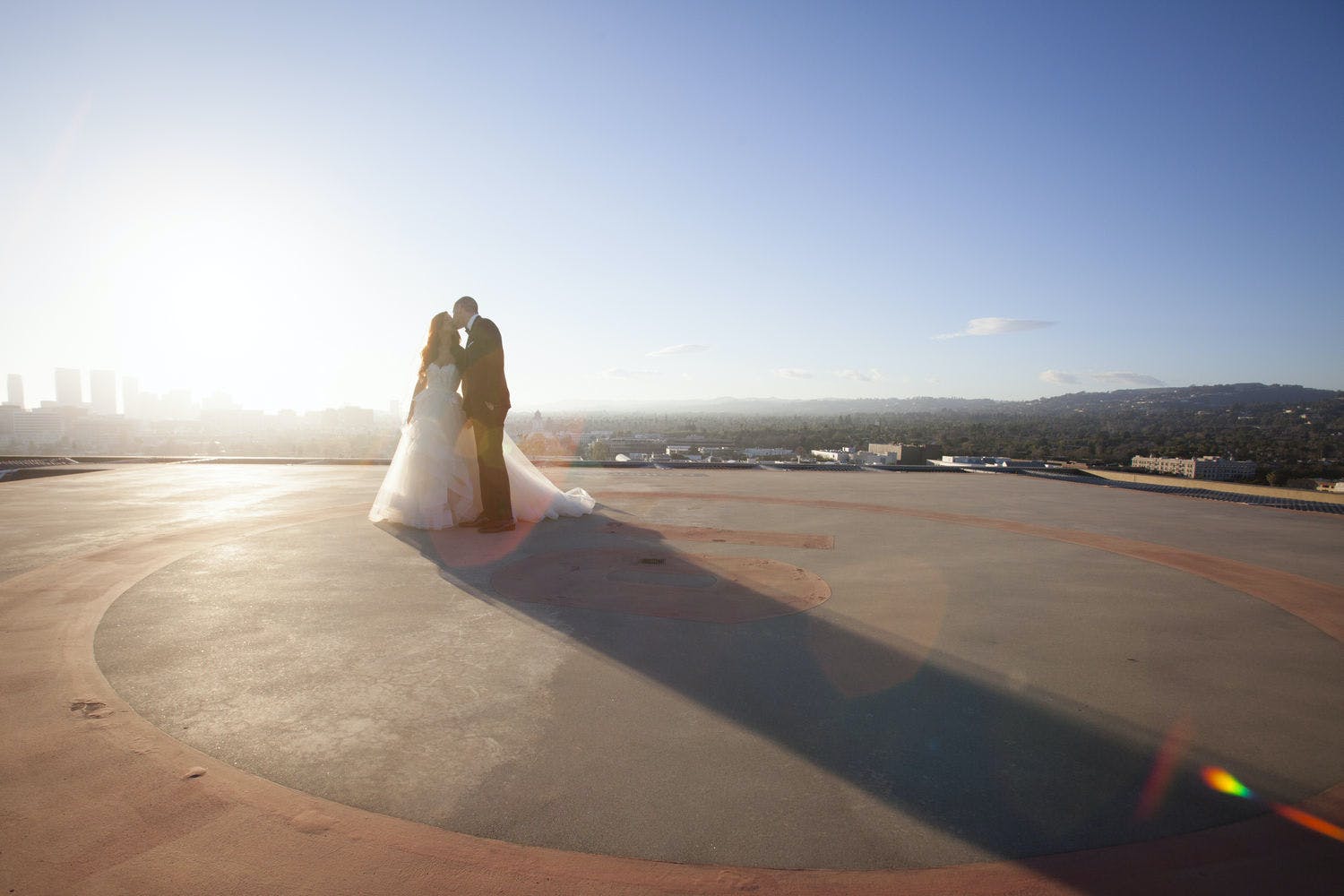 Couple Kissing on Helipad on Top The Four Seasons Beverly Hills Wedding Venue and Honeymoon Destination | PartySlate