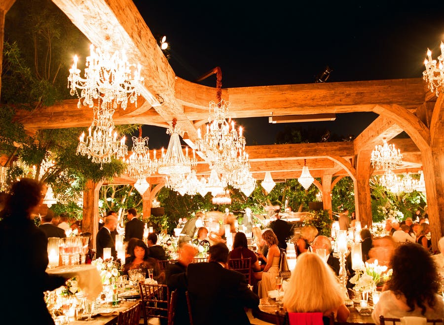 Nighttime Outdoor Mountaintop Reception with Chandeliers and rustic Wood Beams | PartySlate