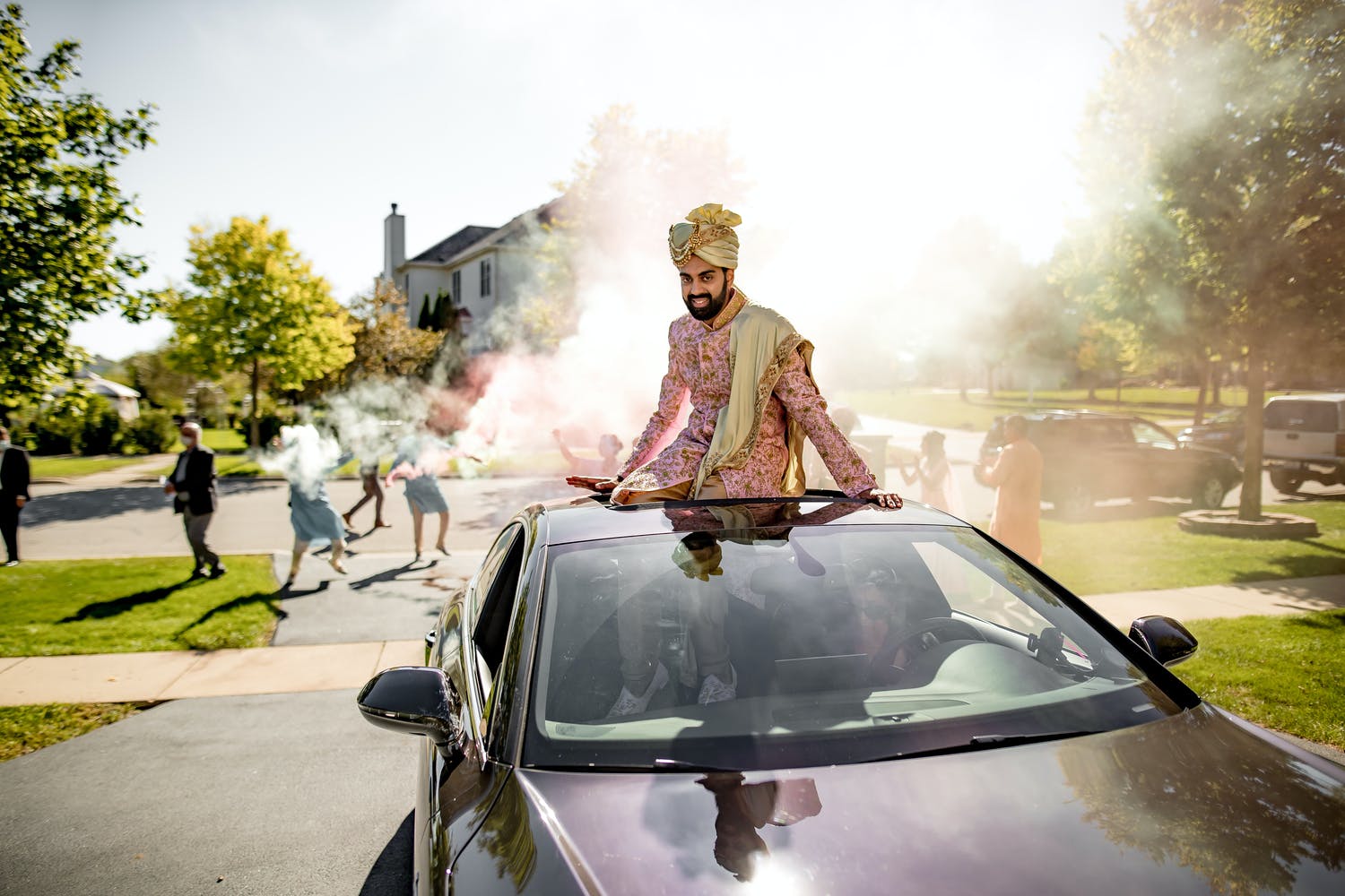 Groom makes baraat entrance in car with open rooftop at intimate backyard wedding | PartySlate