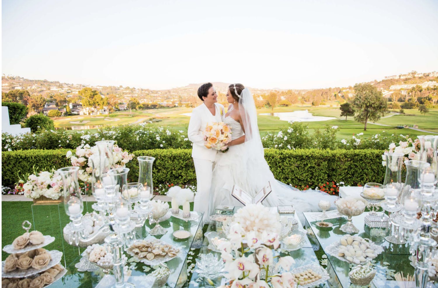 Brides at the Dessert Table of White Wedding with Orange and Pink Details | PartySlate