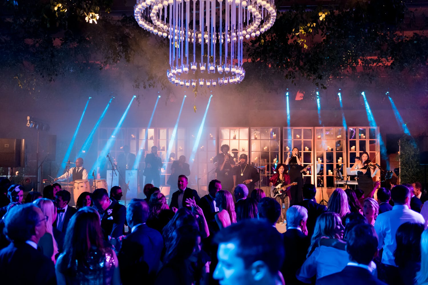 Ballroom wedding with blue laser lights and chandelier of blue ribbon | PartySlate