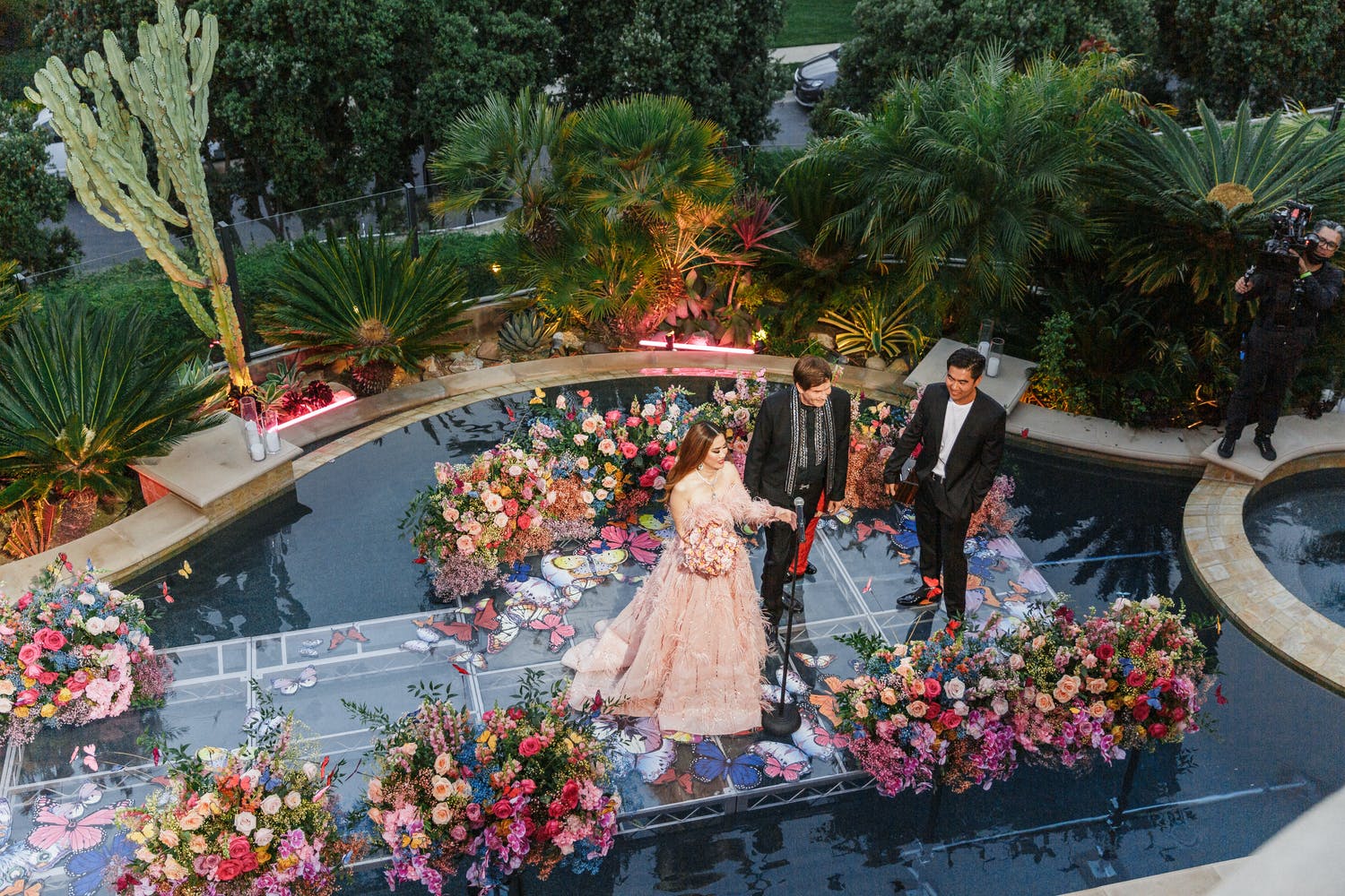 Vow renew on floating aisle covered in bright and colorful flowers | PartySlate
