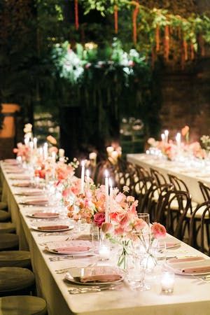 A dinner party with pink décor and candles lit.