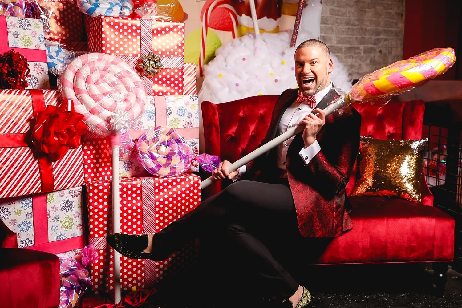 Man hold giant lollipop photo prop at Candy Land theme party | PartySlate