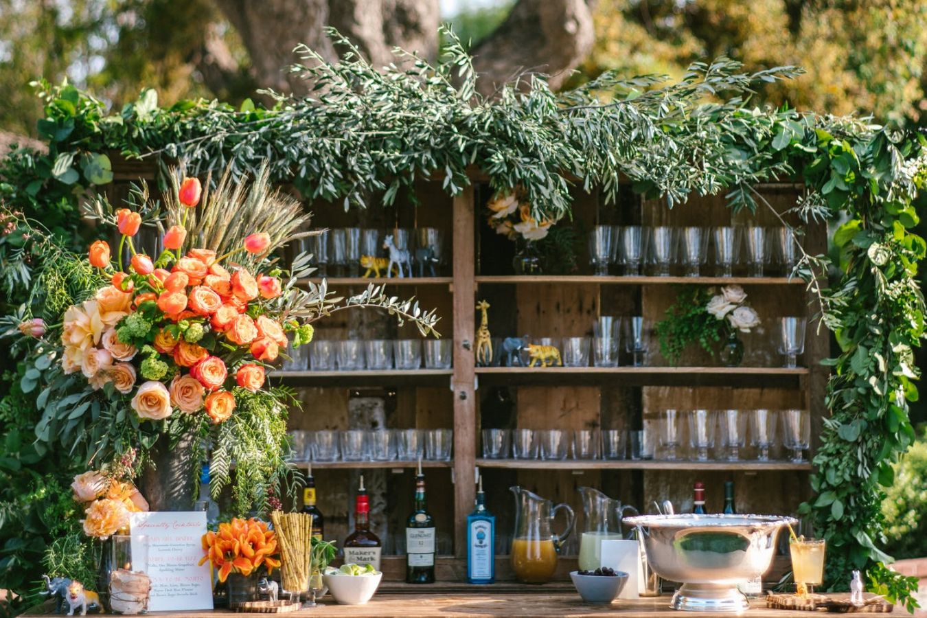 Outdoor bar with foliage and orange flowers | PartySlate