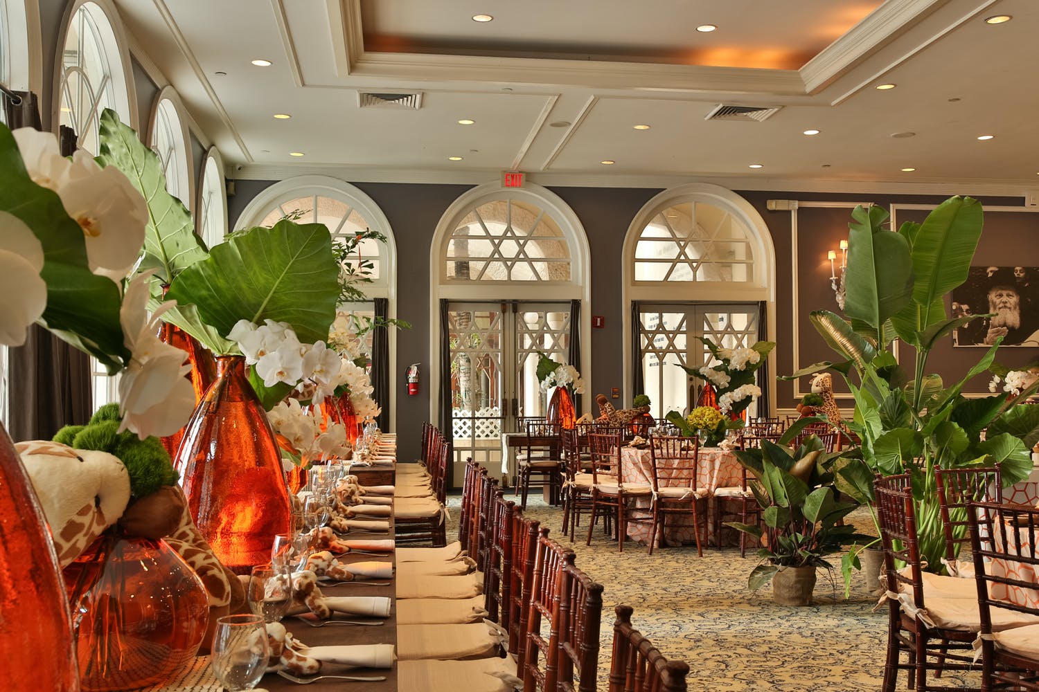 Animal theme baby shower with large tropical leaves and orange vases | PartySlate