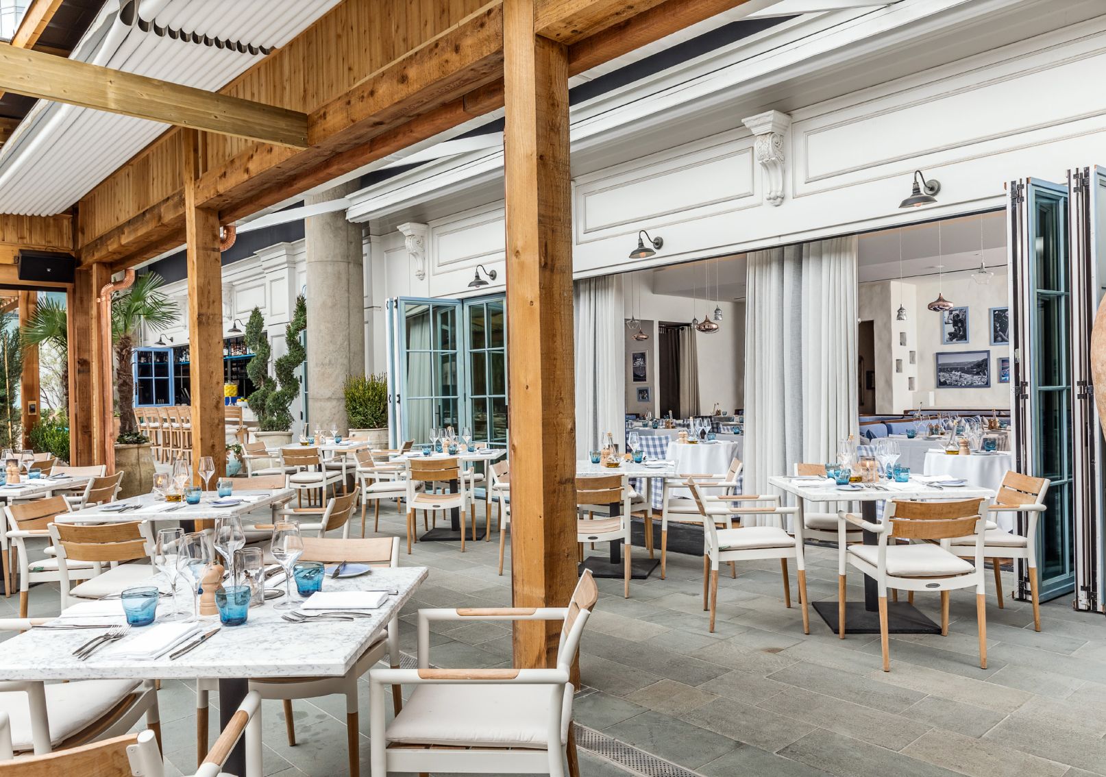 Outdoor private dinging space with accordion doors and wood pillars | PartySlate