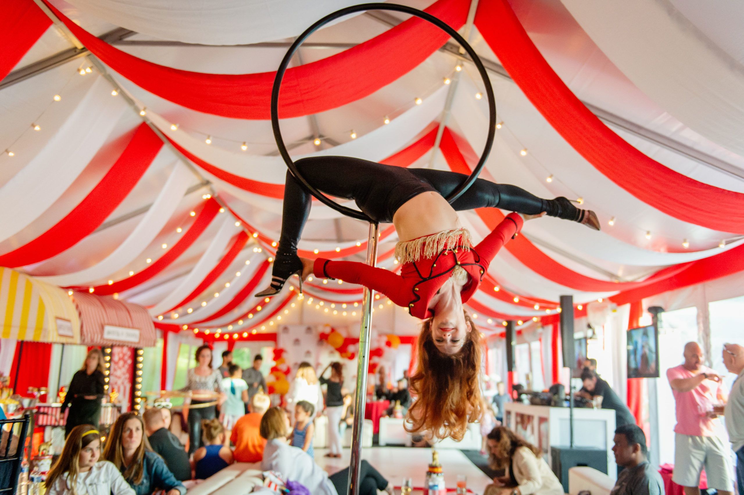 carnival themed party with performer hanging from ceiling | PartySlate