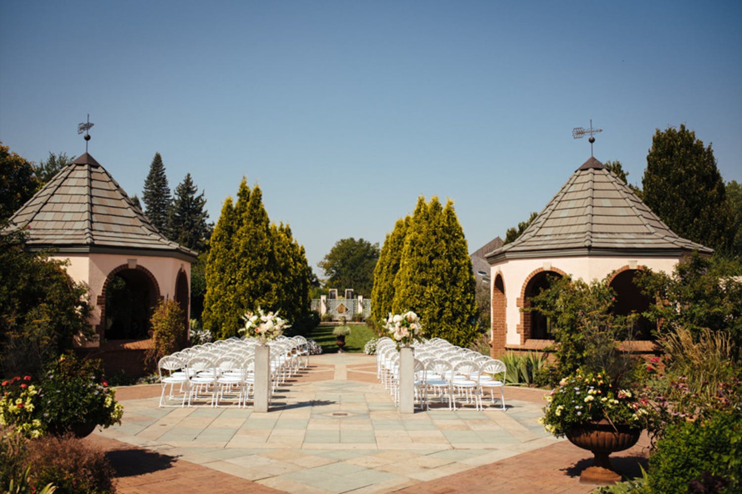 Wedding ceremony in courtyard surrounded by gardens | PartySlate