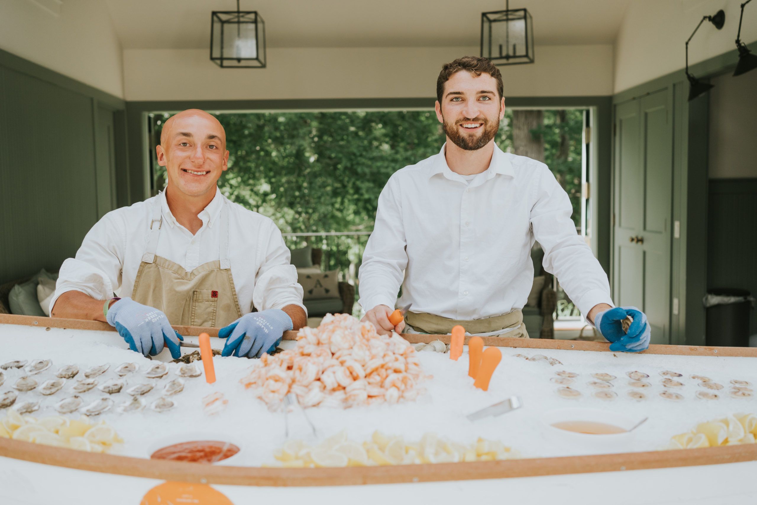 Two men preside over canoe filled with fresh seafood for wedding | PartySlate