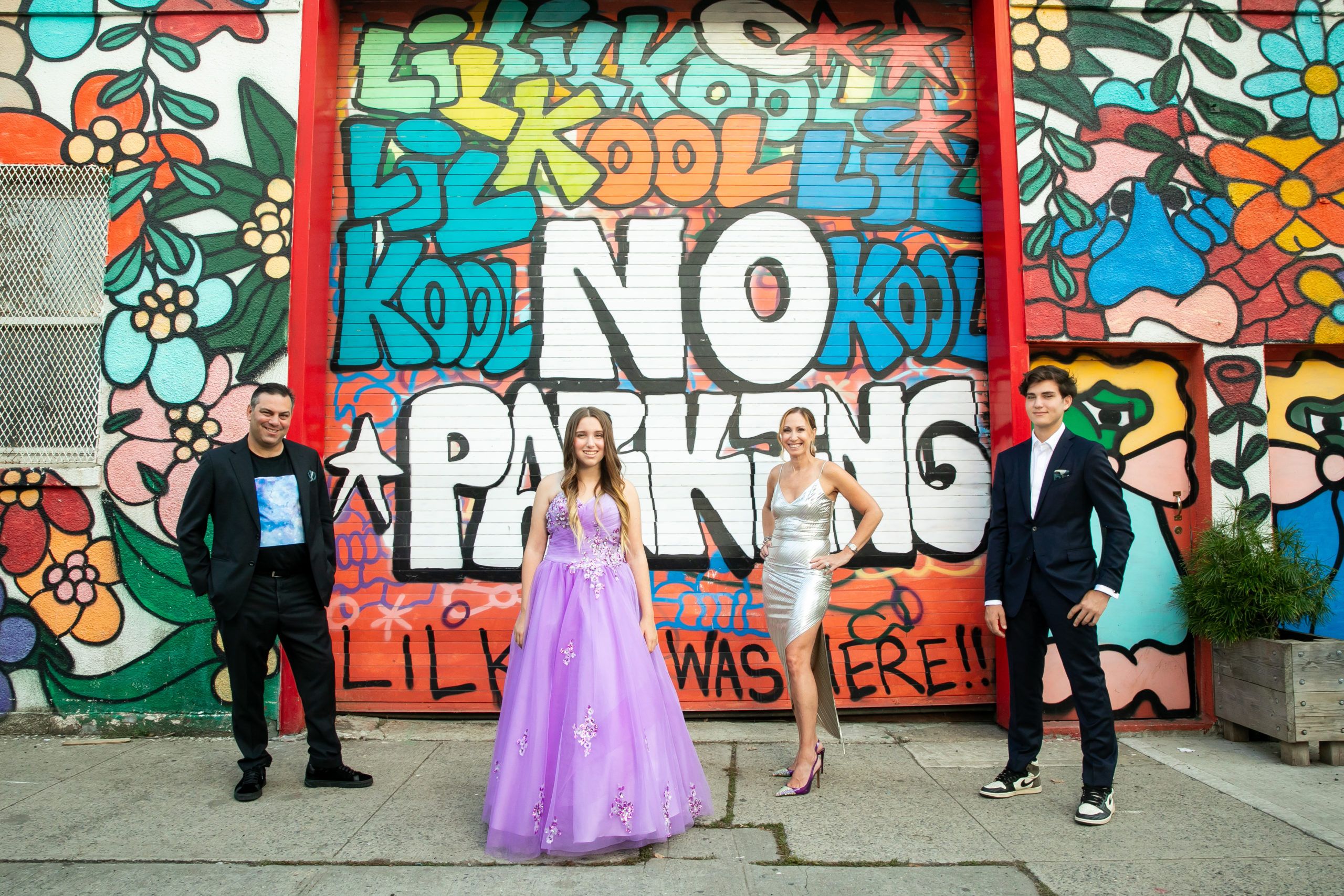 Bat Mitzvah girl poses with her family in front of colorful street art in New York, NY | PartySlate